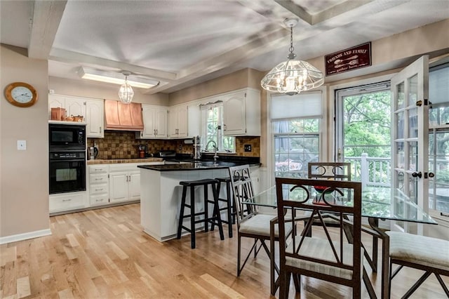 732 W 121st St, Kansas City, MO 64145 - kitchen featuring black appliances, premium range hood, a chandelier, white cabinetry, and backsplash