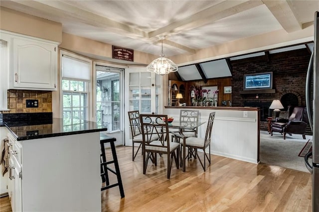 732 W 121st St, Kansas City, MO 64145 - dining area featuring beamed ceiling, light wood finished floors, and a chandelier
