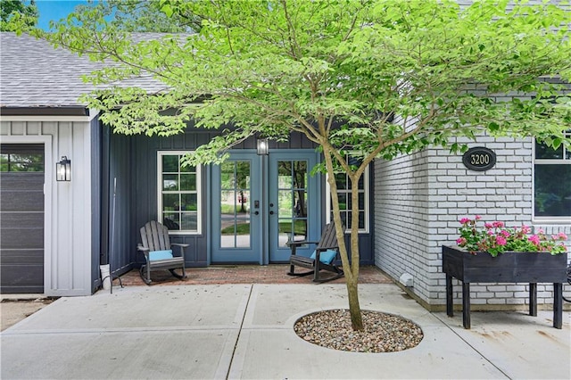 3200 NW 51st Ter, Blue Springs, MO 64015 - property entrance featuring french doors, board and batten siding, roof with shingles, and a patio area