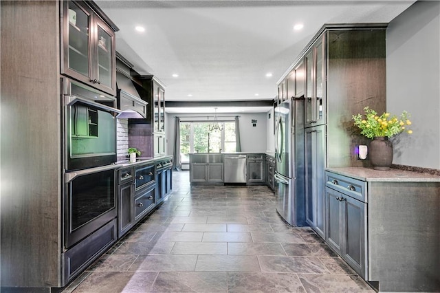 3200 NW 51st Ter, Blue Springs, MO 64015 - kitchen with appliances with stainless steel finishes, glass insert cabinets, recessed lighting, hanging light fixtures, and light stone counters