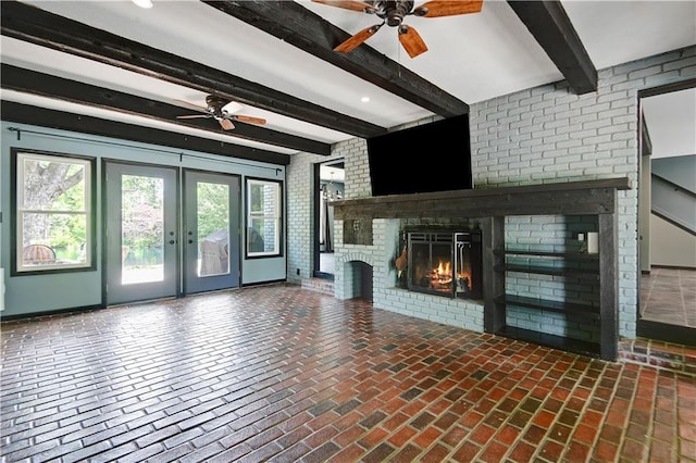 3200 NW 51st Ter, Blue Springs, MO 64015 - unfurnished living room with ceiling fan, beamed ceiling, plenty of natural light, and a brick fireplace
