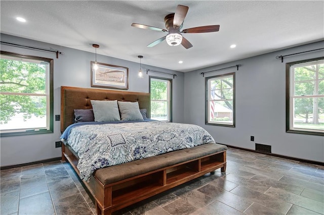 3200 NW 51st Ter, Blue Springs, MO 64015 - bedroom with multiple windows, recessed lighting, ceiling fan, stone finish floors, and a textured ceiling