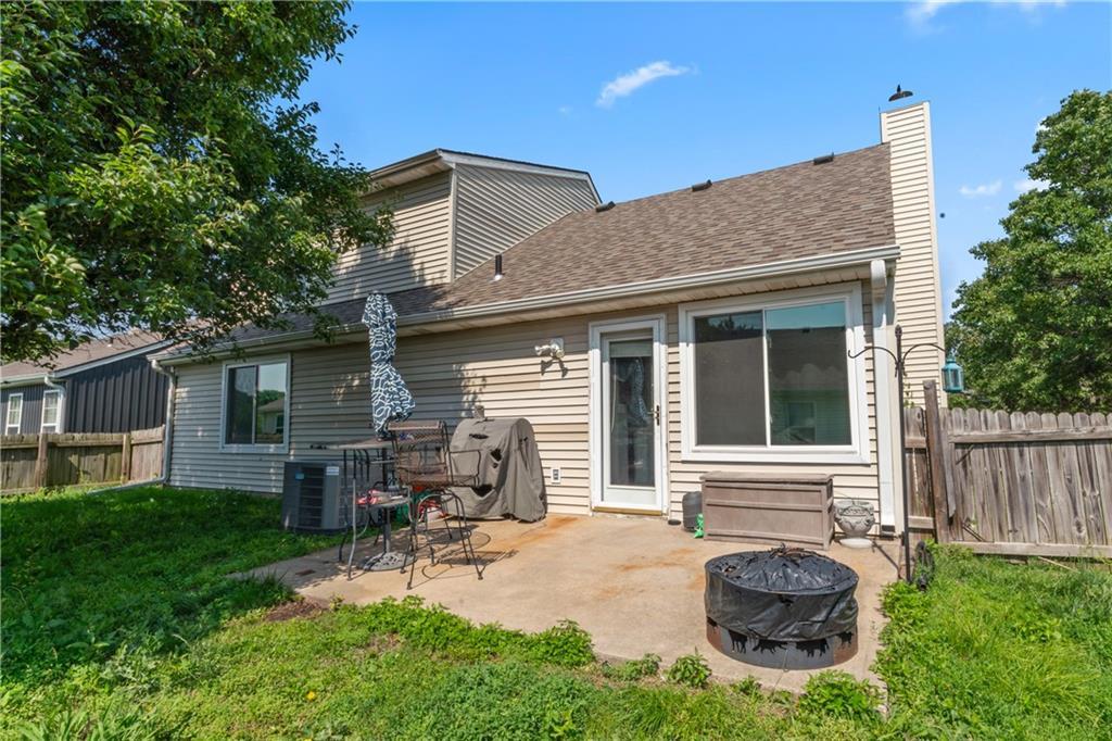 380 N Sumac St, Gardner, KS 66030 - back of property with an outdoor fire pit, a patio, a fenced backyard, a chimney, and roof with shingles