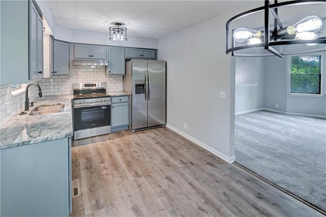 113 SE 250th Rd, Warrensburg, MO 64093 - kitchen with appliances with stainless steel finishes, light stone counters, tasteful backsplash, gray cabinets, and under cabinet range hood