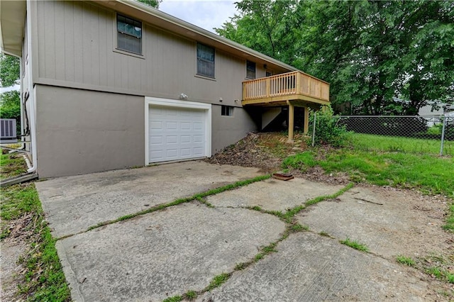 113 SE 250th Rd, Warrensburg, MO 64093 - back of house featuring a garage, a deck, and driveway