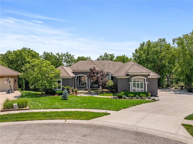 8709 Pine St, Lenexa, KS 66220 - ranch-style home featuring a tile roof, stucco siding, a front yard, and concrete driveway