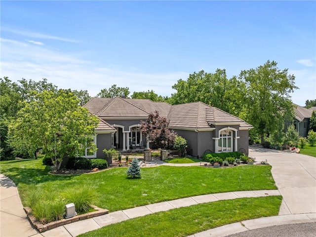 8709 Pine St, Lenexa, KS 66220 - view of front of house with stucco siding, a front yard, a tiled roof, and concrete driveway