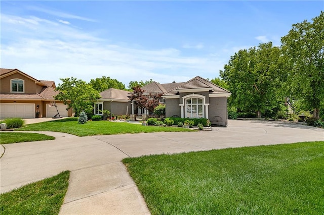 8709 Pine St, Lenexa, KS 66220 - view of front of property with stucco siding, a front lawn, concrete driveway, a tile roof, and a garage