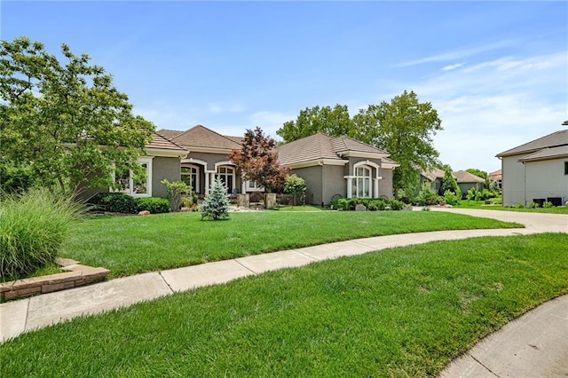 8709 Pine St, Lenexa, KS 66220 - mediterranean / spanish-style house with a front lawn, a tile roof, and stucco siding