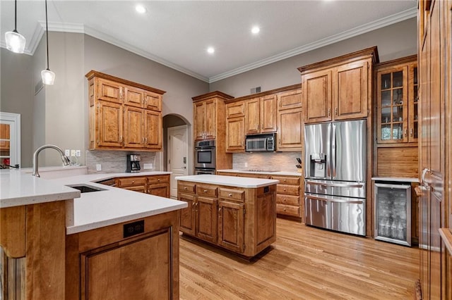 8709 Pine St, Lenexa, KS 66220 - kitchen featuring appliances with stainless steel finishes, beverage cooler, brown cabinets, arched walkways, and light wood-style floors