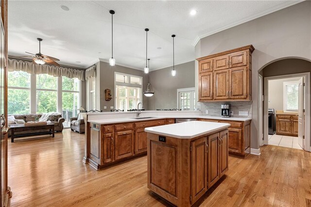 8709 Pine St, Lenexa, KS 66220 - kitchen featuring brown cabinetry, ornamental molding, light countertops, a peninsula, and light wood-type flooring