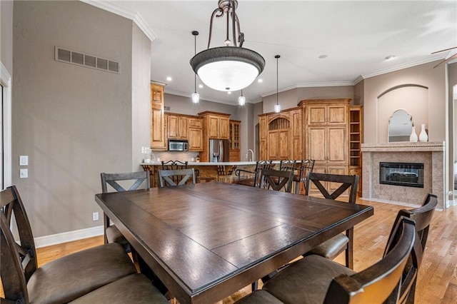 8709 Pine St, Lenexa, KS 66220 - dining room featuring light wood finished floors, a high end fireplace, crown molding, and recessed lighting
