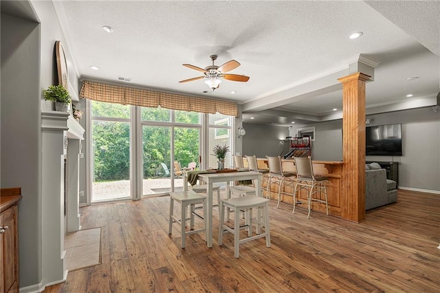8709 Pine St, Lenexa, KS 66220 - dining space with ceiling fan, wood-type flooring, decorative columns, ornamental molding, and a textured ceiling