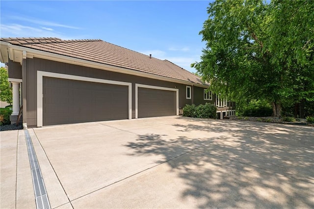 8709 Pine St, Lenexa, KS 66220 - view of front of house with concrete driveway, a tile roof, and a garage