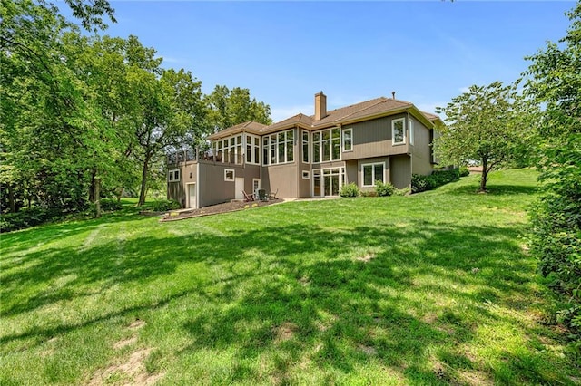 8709 Pine St, Lenexa, KS 66220 - rear view of property with a chimney, a lawn, and a sunroom