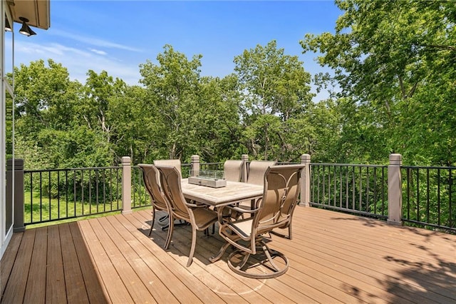 8709 Pine St, Lenexa, KS 66220 - wooden deck featuring outdoor dining area and view of wooded area