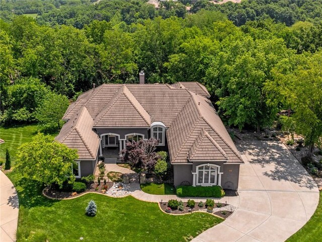 8709 Pine St, Lenexa, KS 66220 - view of front of house featuring a tile roof, stucco siding, a forest view, and a front yard