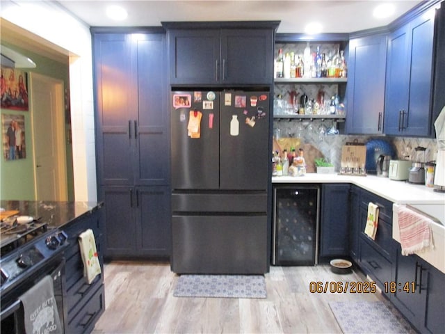 112 Spruce St, Garden City, MO 64747 - kitchen featuring freestanding refrigerator, beverage cooler, black range with gas stovetop, light wood-style flooring, and open shelves