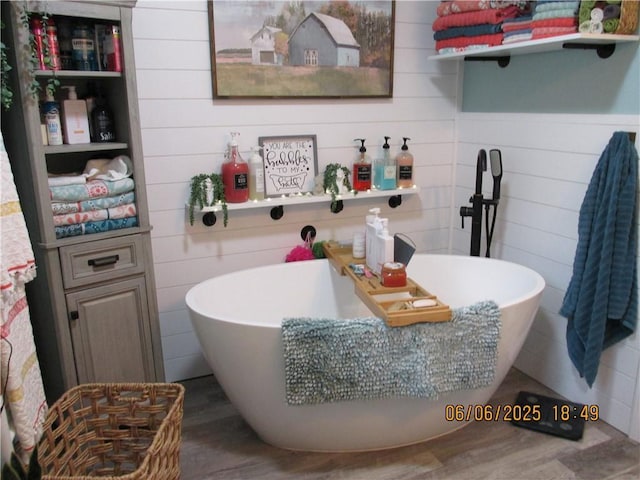 112 Spruce St, Garden City, MO 64747 - full bath with a freestanding tub, wood finished floors, and wood walls