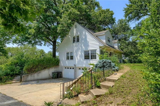 3437 Shrine Park Rd, Leavenworth, KS 66048 - view of property exterior with an attached garage, concrete driveway, and stairs