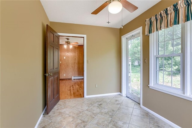 3437 Shrine Park Rd, Leavenworth, KS 66048 - unfurnished room with a ceiling fan, plenty of natural light, a baseboard heating unit, and light tile patterned floors