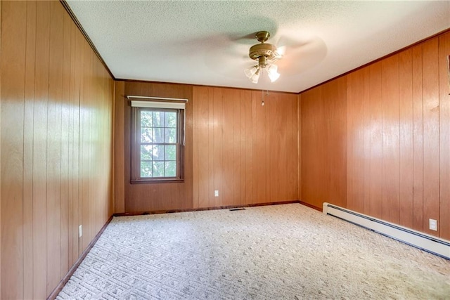 3437 Shrine Park Rd, Leavenworth, KS 66048 - empty room with baseboard heating, ceiling fan, a textured ceiling, wood walls, and carpet flooring