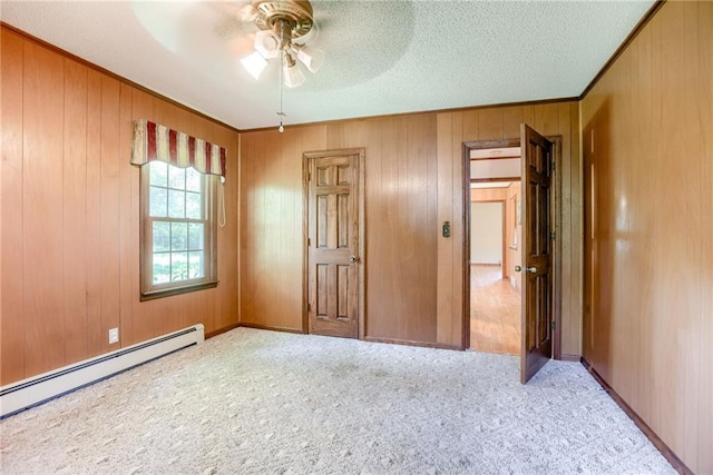 3437 Shrine Park Rd, Leavenworth, KS 66048 - unfurnished bedroom with a baseboard heating unit, ornamental molding, carpet, wood walls, and a textured ceiling