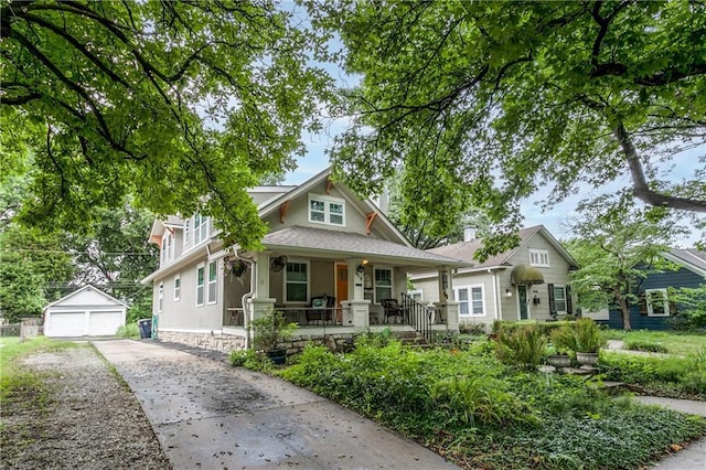 5914 Holmes St, Kansas City, MO 64110 - bungalow-style home featuring covered porch, a garage, an outbuilding, and stucco siding