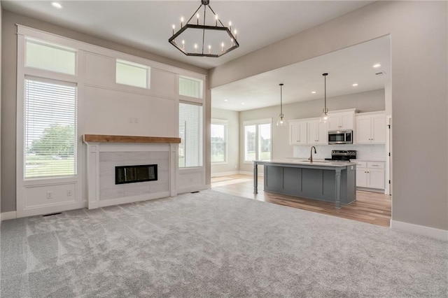18722 W 169th Ter, Olathe, KS 66062 - kitchen with stainless steel microwave, light carpet, a sink, range with electric stovetop, and recessed lighting
