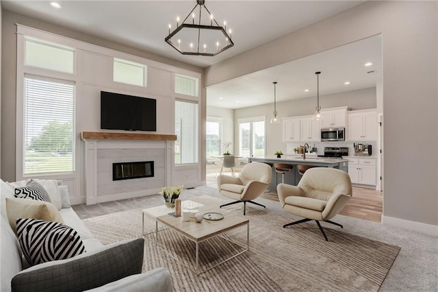 18722 W 169th Ter, Olathe, KS 66062 - living area with recessed lighting, light colored carpet, a chandelier, a tiled fireplace, and baseboards