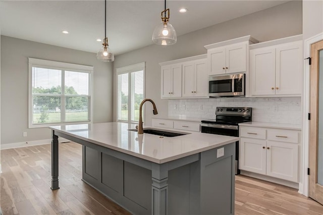 18722 W 169th Ter, Olathe, KS 66062 - kitchen with stainless steel appliances, a sink, light countertops, backsplash, and an island with sink