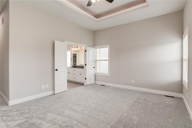 18722 W 169th Ter, Olathe, KS 66062 - unfurnished bedroom featuring light colored carpet, a raised ceiling, baseboards, and ensuite bathroom