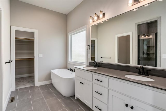 18722 W 169th Ter, Olathe, KS 66062 - bathroom featuring double vanity, a soaking tub, a walk in closet, a shower stall, and baseboards