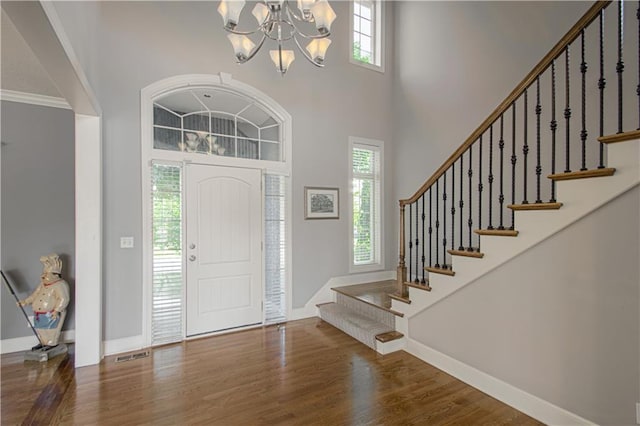 16321 Nieman Rd, Overland Park, KS 66062 - foyer entrance with plenty of natural light, wood finished floors, a chandelier, a high ceiling, and stairs