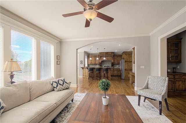 16321 Nieman Rd, Overland Park, KS 66062 - living area with arched walkways, light wood-style flooring, ornamental molding, a ceiling fan, and recessed lighting