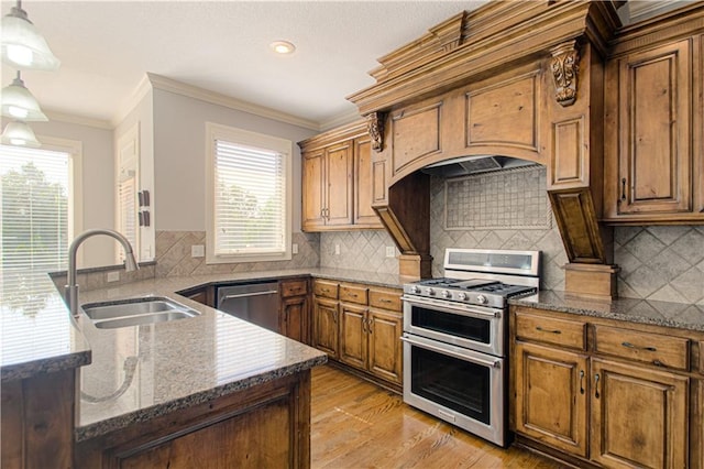 16321 Nieman Rd, Overland Park, KS 66062 - kitchen with stainless steel appliances, a peninsula, light wood-style floors, brown cabinets, and dark stone countertops