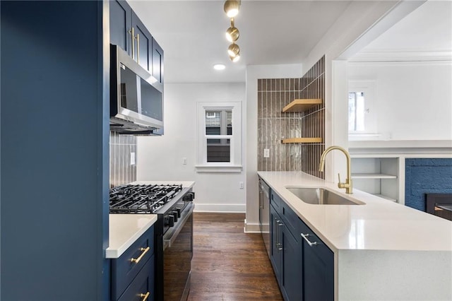 17 E 65th Ter, Kansas City, MO 64113 - kitchen with stainless steel appliances, blue cabinets, open shelves, light countertops, and dark wood-type flooring