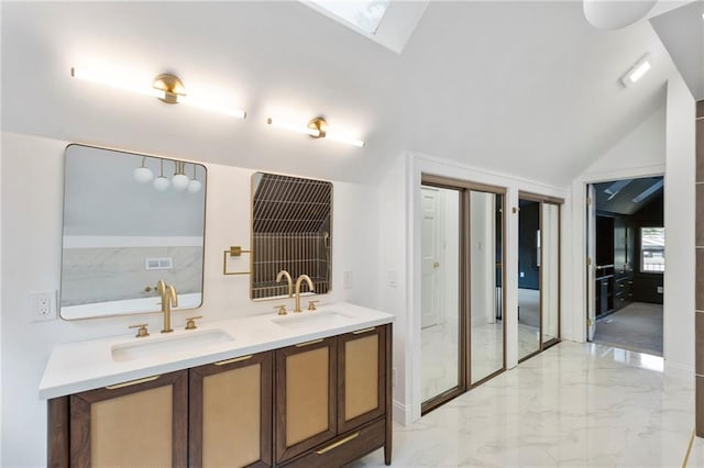 17 E 65th Ter, Kansas City, MO 64113 - bathroom featuring marble tiled flooring, a skylight, double vanity, and vaulted ceiling