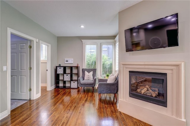 14911 Outlook Ln, Overland Park, KS 66223 - sitting room with wood finished floors, a glass covered fireplace, and recessed lighting