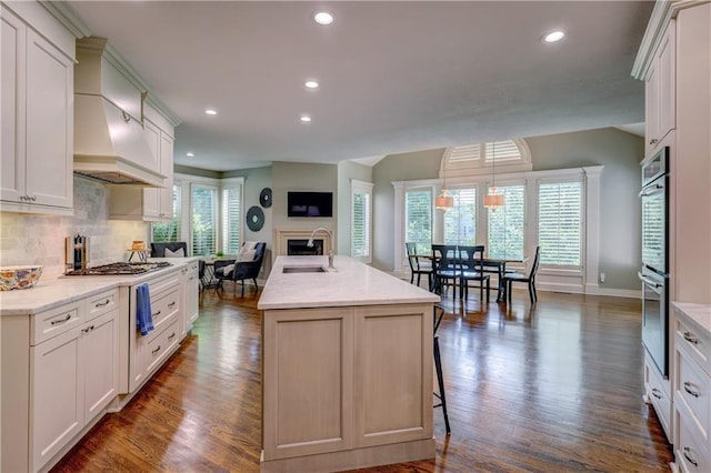 14911 Outlook Ln, Overland Park, KS 66223 - kitchen with a fireplace, dark wood finished floors, stainless steel appliances, recessed lighting, and decorative backsplash