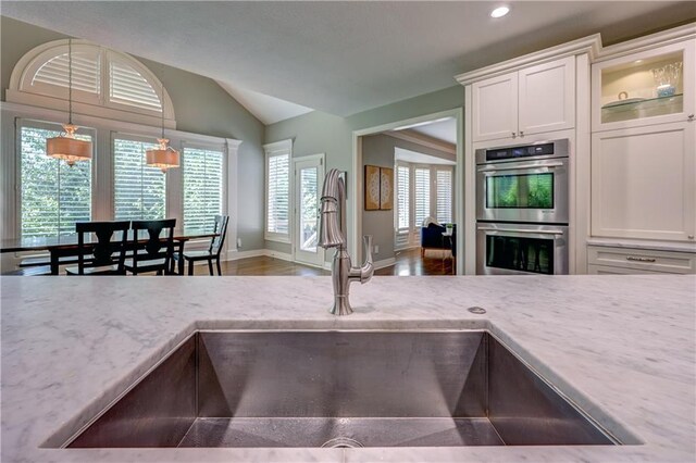 14911 Outlook Ln, Overland Park, KS 66223 - kitchen featuring double oven, lofted ceiling, white cabinets, recessed lighting, and decorative light fixtures