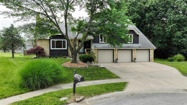 3437 N Wabash Ave, Kansas City, MO 64116 - view of front facade featuring stone siding, driveway, a front lawn, and a garage