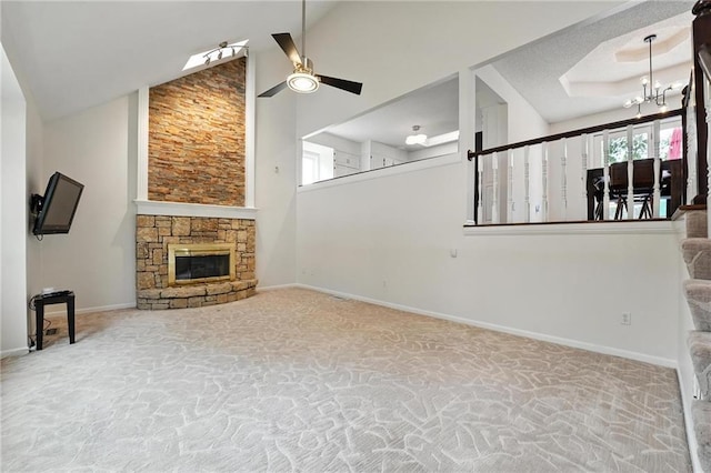 3437 N Wabash Ave, Kansas City, MO 64116 - unfurnished living room with carpet, a ceiling fan, high vaulted ceiling, a stone fireplace, and a chandelier