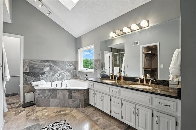 3437 N Wabash Ave, Kansas City, MO 64116 - bathroom with a garden tub, double vanity, a skylight, a stall shower, and marble tiled floors