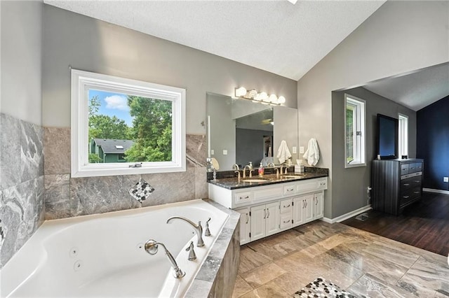 3437 N Wabash Ave, Kansas City, MO 64116 - full bathroom with double vanity, lofted ceiling, a tub with jets, and a textured ceiling