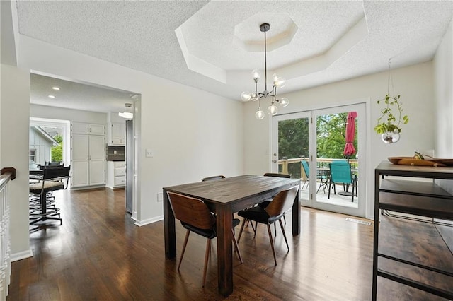 3437 N Wabash Ave, Kansas City, MO 64116 - dining area featuring dark wood-style floors, a textured ceiling, a raised ceiling, and a chandelier