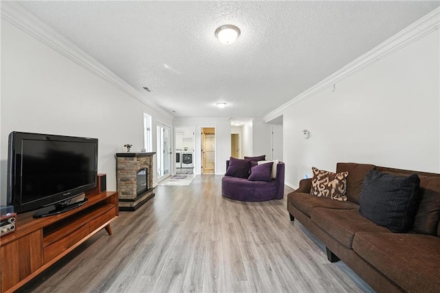3437 N Wabash Ave, Kansas City, MO 64116 - living room with wood finished floors, a textured ceiling, crown molding, and a fireplace