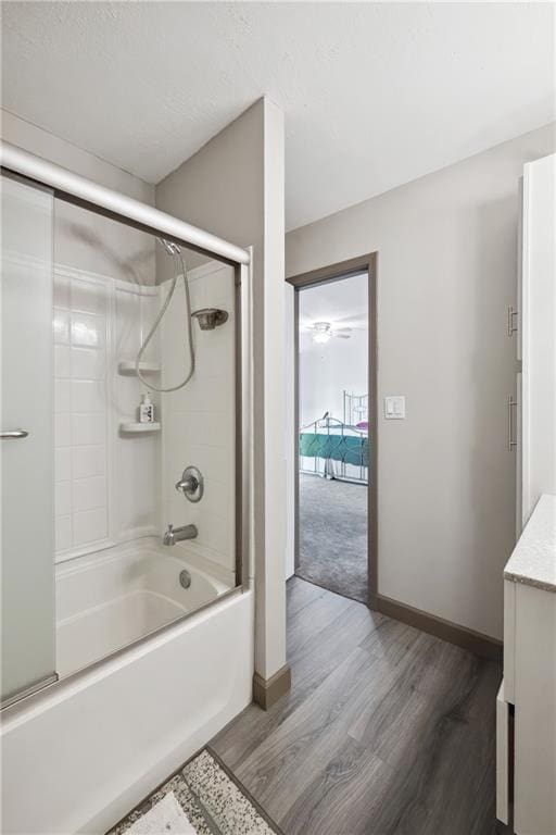 19109 Quinn Rd, Trimble, MO 64492 - full bath with wood finished floors, combined bath / shower with glass door, vanity, and baseboards