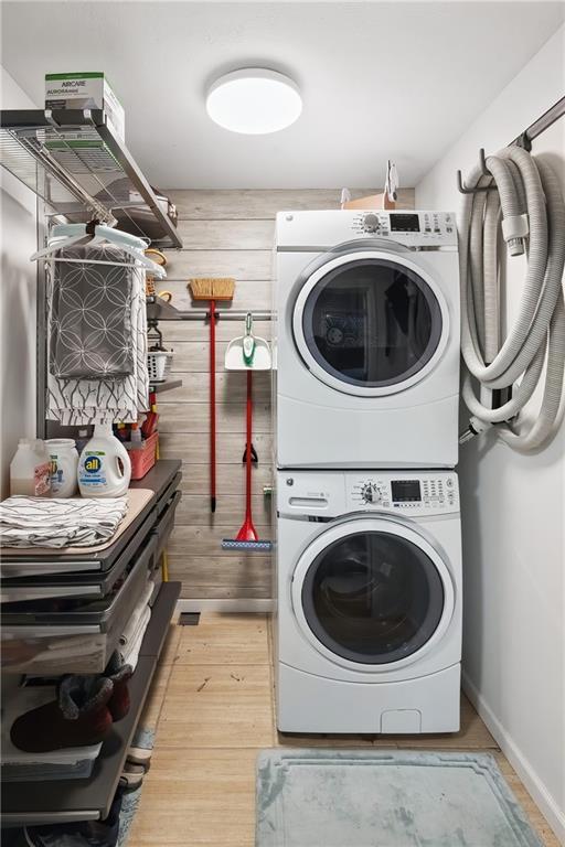 19109 Quinn Rd, Trimble, MO 64492 - laundry area with stacked washer / drying machine, light wood-type flooring, and baseboards