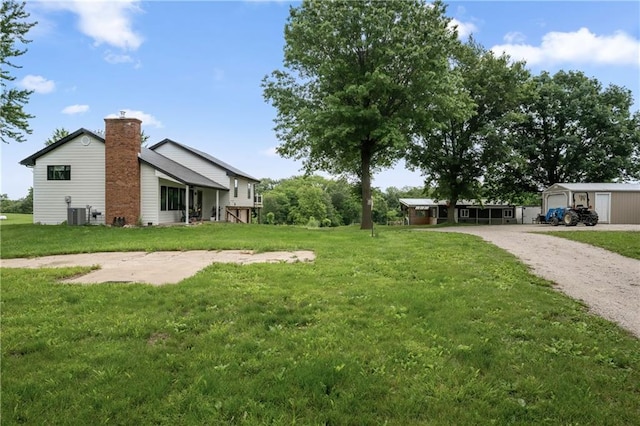 19109 Quinn Rd, Trimble, MO 64492 - view of green lawn with gravel driveway, an outbuilding, and central AC unit